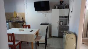 Il comprend une cuisine avec une table et des chaises ainsi qu'une petite cuisine équipée d'un réfrigérateur. dans l'établissement Alojamiento Palpalá, à Palpalá