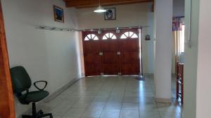 un couloir avec une porte en bois et une chaise dans l'établissement Alojamiento Palpalá, à Palpalá