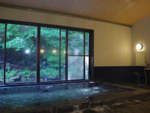 an empty room with a large window and a hot tub at あじ彩の宿小浜荘 in Toba