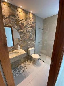 a stone bathroom with a toilet and a sink at Alquiler de Casa en San Bernardino ::: 1.500.000 Gs. por día in Ypacarai