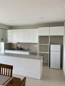a kitchen with white cabinets and a white refrigerator at Alquiler de Casa en San Bernardino ::: 1.500.000 Gs. por día in Ypacarai