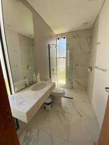 a bathroom with a sink and a toilet and a mirror at Alquiler de Casa en San Bernardino ::: 1.500.000 Gs. por día in Ypacarai