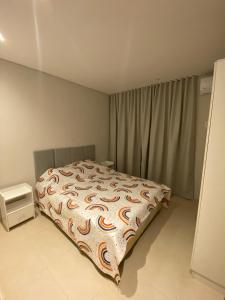 a bedroom with a bed with a comforter on it at Alquiler de Casa en San Bernardino ::: 1.500.000 Gs. por día in Ypacarai