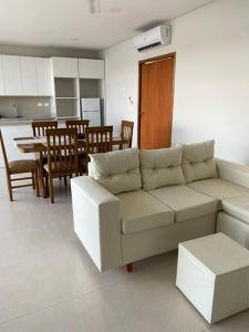 a living room with a white couch and a kitchen at Alquiler de Casa en San Bernardino ::: 1.500.000 Gs. por día in Ypacarai