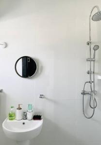 ein weißes Badezimmer mit einem Waschbecken und einem Spiegel in der Unterkunft Lekki Minimalist Studio in Lagos