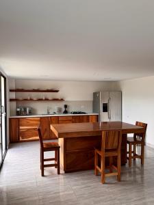 a kitchen with a table and chairs and a refrigerator at Habitación con Baño Privado en Casa Campestre in Sabaneta