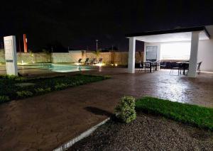 a pavilion with a table and chairs at night at E&S Estancia vacacional in Mazatlán +2 photos