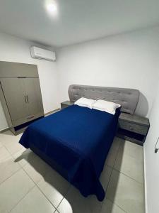 um quarto com uma cama azul num quarto em E&S Estancia vacacional em Mazatlán