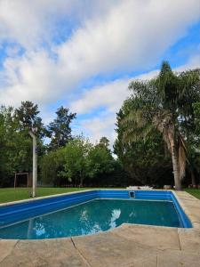 a swimming pool in a yard with a palm tree at Casa Quinta 2000 M² en centro de Francisco Álvarez in Francisco Álvarez