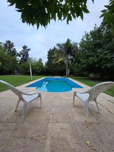 two chairs sitting in front of a swimming pool at Casa Quinta 2000 M² en centro de Francisco Álvarez in Francisco Álvarez