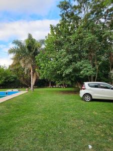 un coche blanco aparcado en un patio junto a un árbol en Casa Quinta 2000 M² en centro de Francisco Álvarez en Francisco Álvarez