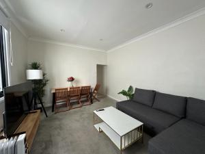 a living room with a couch and a table at Dynamic 2 Bedroom home close to city buzz Darling St 2 E-Bikes Included in Sydney