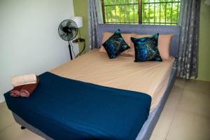 a bed with blue sheets and pillows in a bedroom at Family Homestay in Nadi