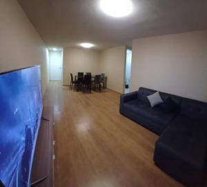 a living room with a couch and a flat screen tv at COMODO DEPARTAMENTO EN Chiclayo in Chiclayo