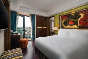 a hotel room with a large bed and a balcony at Peridot Gallery Classic Hotel in Hanoi