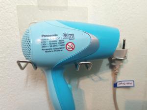 a blue hair dryer hanging on a wall at The Backpacker stn in Nonthaburi