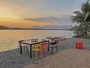 uma mesa e cadeiras na costa de uma massa de água em Garden Riverside em Kampot