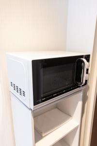 a microwave oven sitting on top of a refrigerator at KIKU'S Room in Osaka