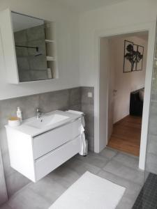 ein Badezimmer mit einem weißen Waschbecken und einem Spiegel in der Unterkunft Ferienwohnung Bergnest in Niederndorferberg