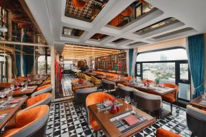 a restaurant with tables and chairs and a window at Peridot Gallery Classic Hotel in Hanoi