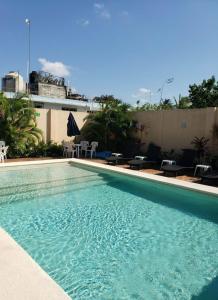 una piscina con sillas y un edificio en Coral Island Suites Cozumel, en Cozumel
