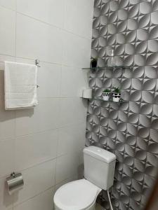 La salle de bains est pourvue de toilettes et d'un mur. dans l'établissement Apartamento mobiliado, à Porto Velho