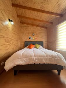 a bedroom with a large bed with wooden walls at Departamento Nu_Be2 Castro Chiloé in Castro