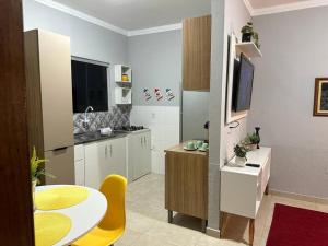 une cuisine avec une table et une chaise jaune dans l'établissement Apartamento mobiliado, à Porto Velho
