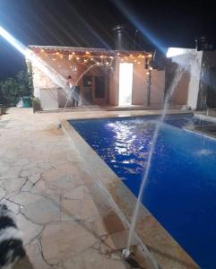 una fontana di fronte alla piscina di notte di CASA FINCA PARA VACACIONAR a Turbaco