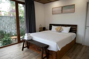 a bedroom with a large bed and a large window at OLIVE Camping in Lagi