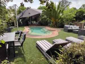 a backyard with a pool and a table and chairs at Coach House Inn in Bright