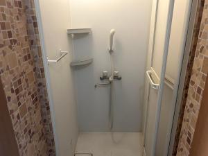 a shower stall in a bathroom with a shower at Hostel JAQ takamatsu in Takamatsu