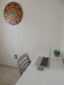 um computador portátil sentado numa mesa branca com uma cadeira em KAN ARG. em Mendoza