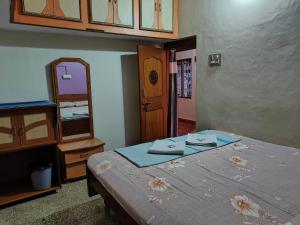 a bedroom with a bed with a dresser and a mirror at Rocky Guesthouse in Hampi