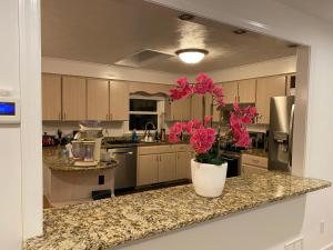 a kitchen with a vase with pink flowers on a counter at Guest house for group of 8 people in Charlottesville