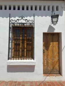 een wit gebouw met een poort en een houten deur bij AptoPardo1945 in Mompos