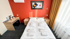 a hotel room with a bed and red walls at Отель KOKSHETAU in Kokshetau