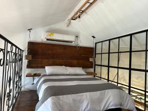 1 dormitorio con 1 cama grande en una habitación con ventanas en AptoPardo1945, en Mompox