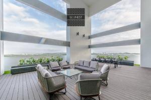 a patio with chairs and a table on a deck at Lovely Eco Home in Gelang Patah