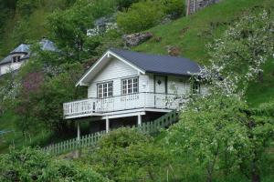 a white house with a balcony on a hill at Maråk Hytteutleige in Geiranger