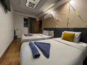 um quarto de hotel com três camas com toalhas em Ibis Pyramids&Museum view no Cairo