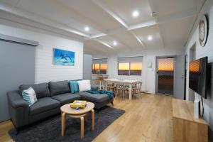 a living room with a couch and a table at OCEA84 - Quinns Beach Shack: Ocean Views in Quinns Rocks