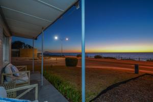 a view of the beach at night from the porch of a house at OCEA84 - Quinns Beach Shack: Ocean Views in Quinns Rocks