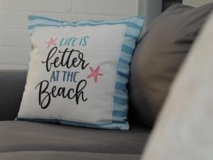 a pillow that says life is better at the beach at OCEA84 - Quinns Beach Shack: Ocean Views in Quinns Rocks