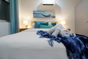 a bedroom with a bed with a blue blanket on it at OCEA84 - Quinns Beach Shack: Ocean Views in Quinns Rocks