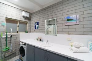 a bathroom with a sink and a washing machine at OCEA84 - Quinns Beach Shack: Ocean Views in Quinns Rocks