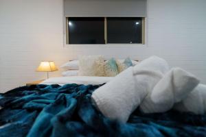 a white teddy bear laying on a bed at OCEA84 - Quinns Beach Shack: Ocean Views in Quinns Rocks