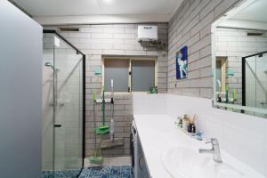 a bathroom with a sink and a shower at OCEA84 - Quinns Beach Shack: Ocean Views in Quinns Rocks