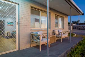 a screened in porch with two chairs and a table at OCEA84 - Quinns Beach Shack: Ocean Views in Quinns Rocks