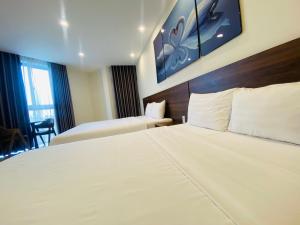 a hotel room with two beds and a chair at MARINA Bình Dương in Ấp Phú Thọ